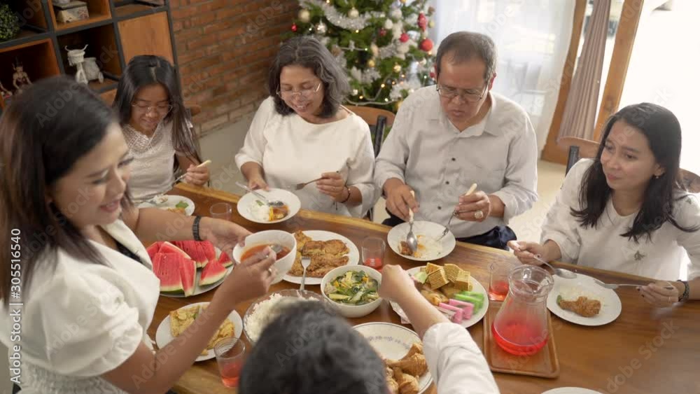 asian family fun having lunch with friends in diningroom together on christmas celebration asian family fun having lunch with friends in diningroom together on christmas celebration