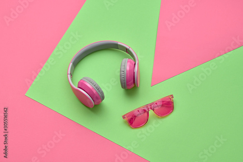 Minimal fashion, Trendy pink headphones. Music vibration on geometry background. Hipster DJ music accessory Flat lay. Art creative summer vibes, fashionable pop art style. Bright design pink color