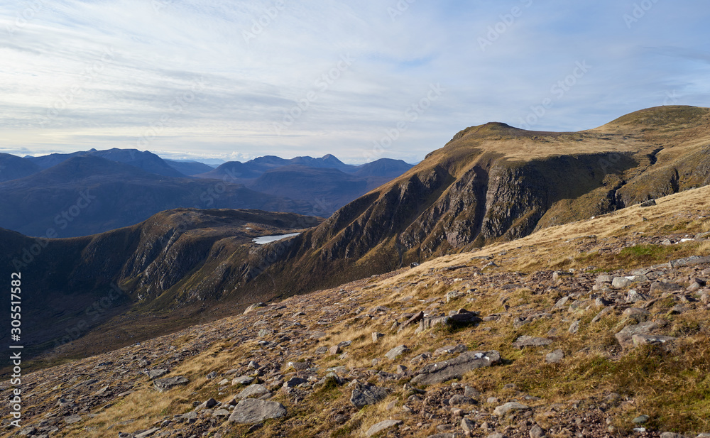 The steep cliffs in the distance that lead up to the ridge route to the summit of Slioch in the Scottish Highlands. The steep cliffs in the distance that lead up to the ridge route to the summit of Slioch in the Scottish Highlands.