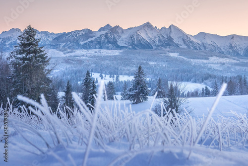 Winter mountains at dawn. Scenic snowy summits in the morning. Sunrise in frosty mountains