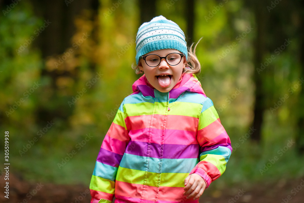 Little girl plays and runs in autumn park. The child walks in nature Little girl plays and runs in autumn park. The child walks in nature