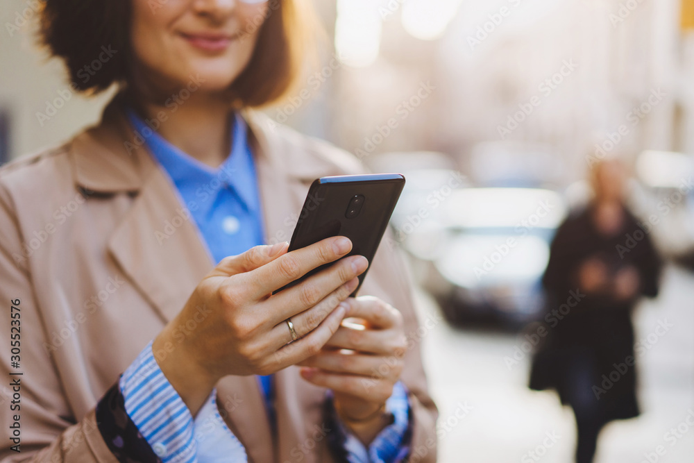 Close up of female hands holding and using modern smartphone outdoor while connecting to WiFi, social media concept Close up of female hands holding and using modern smartphone outdoor while connecting to WiFi, social media concept