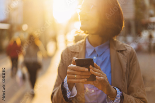 Funny woman in casual wear laughing at content from social networks using mobile phone, positive millennial generation hipster girl satisfied with tariffs for 4G internet on smartphone.