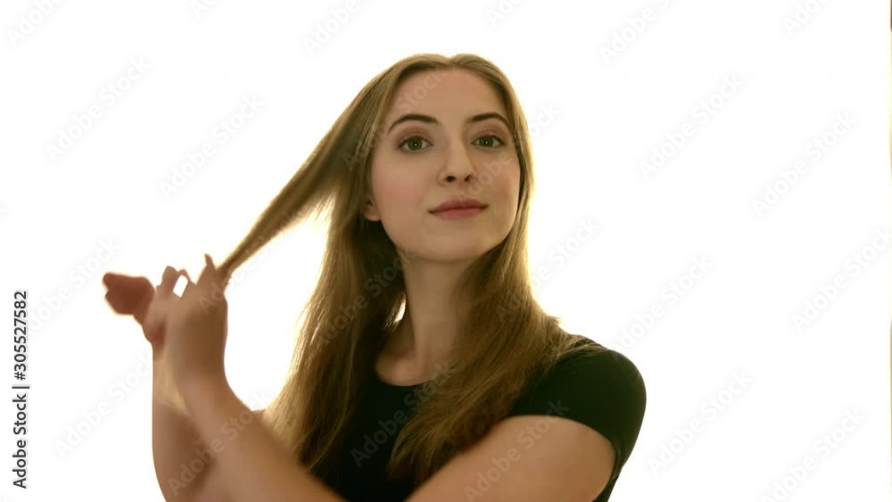 Beautiful girl fixing her blonde hair. Attractive woman combs herself wearing black casual shirt on isolated white background with copy space Beautiful girl fixing her blonde hair. Attractive woman combs herself wearing black casual shirt on isolated white background with copy space