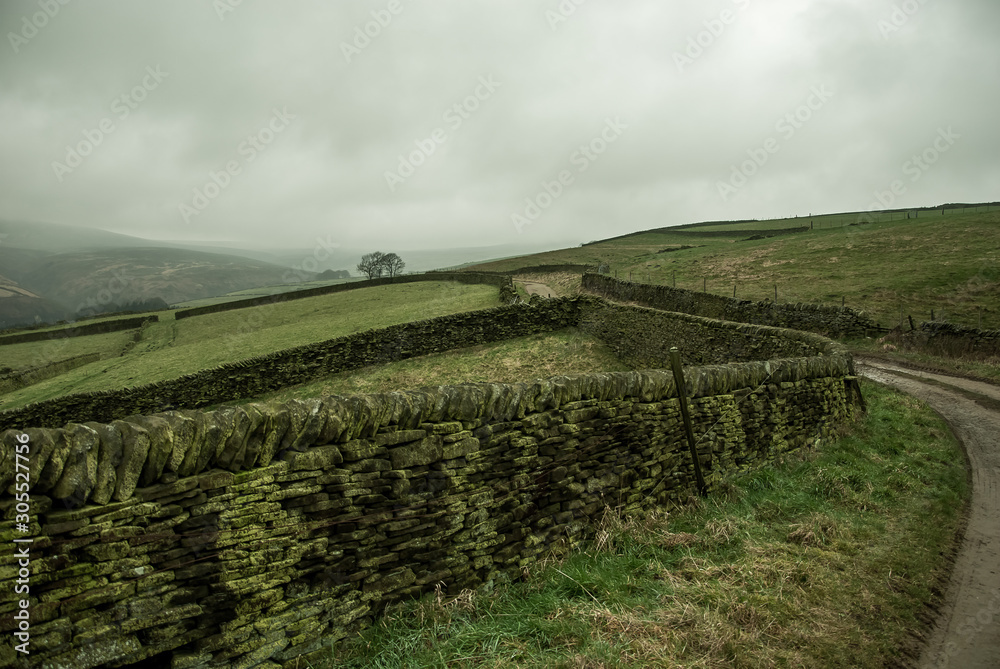 Long stone wall between pastures in the national park. Peak District, United Kingdom. 