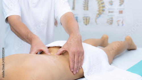 Young woman receiving a low back massage in a physiotherapy center