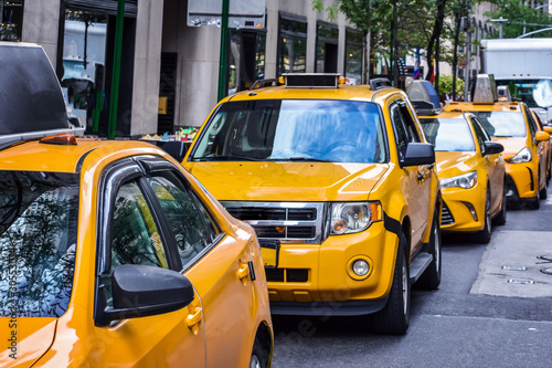 Row of yellow taxis from New York City on the street. Concept of transport and travel. Manhattan, New York, USA