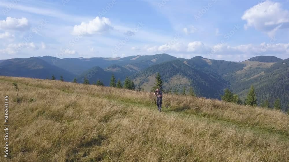 4K .Aerial. Man photographer shoot landscape on ridge in autumn mountain hill. Fly direct 4K .Aerial. Man photographer shoot landscape on ridge in autumn mountain hill. Fly direct