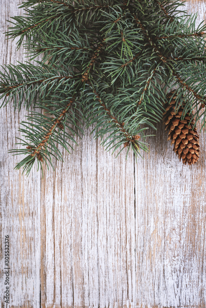 Greeting card for the Christmas holidays. Decoration of green fir branches on wooden background. Great for banners, flyers, party posters, headers. Space for text. Top view Greeting card for the Christmas holidays. Decoration of green fir branches on wooden background. Great for banners, flyers, party posters, headers. Space for text. Top view
