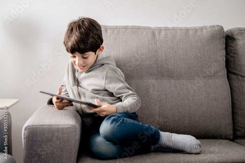 A boy concentrated playing with a tablet