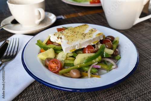 Greek salad with feta cheese. Bright juicy vegetable salad with olives, tomatoes, cucumber.