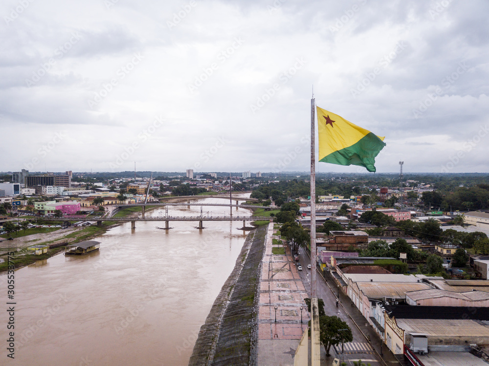 Aerial drone view of Acre river and flag in the amazon. Rio Branco city  center buildings, houses, streets, bridges on cloudy day. Brazil. Concept  of environment, ecology, climate change and travel. Stock