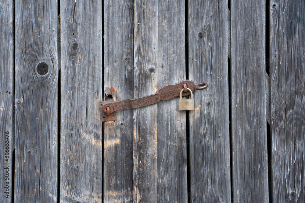 Detail of weathered planks of a shelter with a rusty padlock Detail of weathered planks of a shelter with a rusty padlock