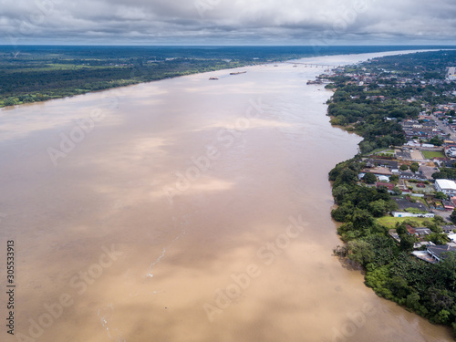 Aerial drone view of Madeira river, Porto Velho city center and Amazon rainforest in the background on cloudy winter day. Concept of environment, ecology, global warming, climate change and travel.