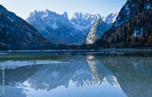 Autumn peaceful alpine lake Durrensee or Lago di Landro. Snow-capped Cristallo rocky mountain group behind, Dolomites, Italy, Europe. Seasonal and nature beauty concept. People and cars unrecognizable photo