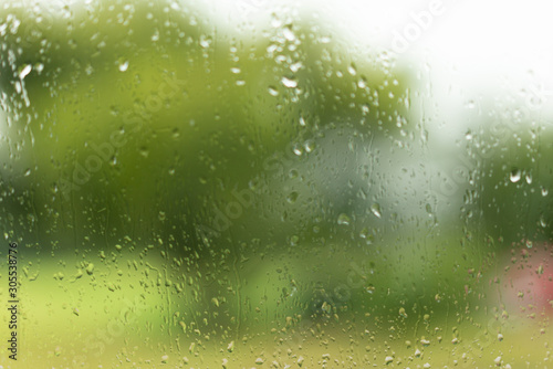 View through a wet glas, green unsharp background