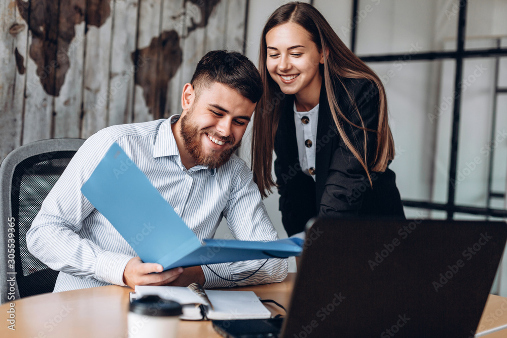 Obraz premium A smiling manager and his assistant work in the office