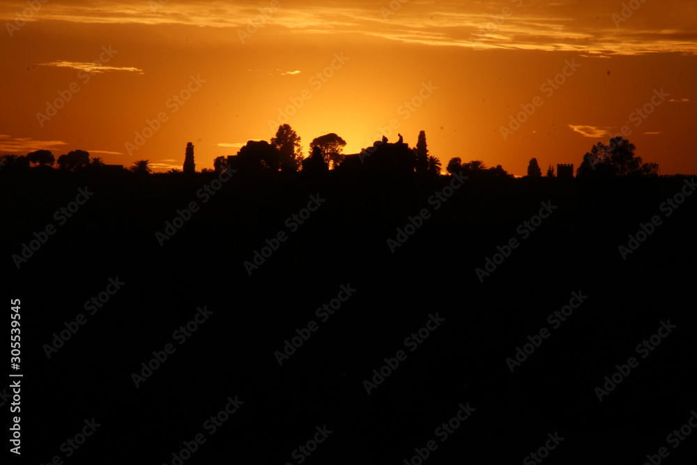 Fez on an orange sunset and the sun in the background. Morocco
