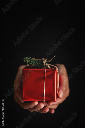 Crop person showing Christmas gift photo