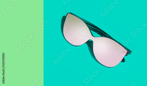 Fashionable eyeglasses with empty glasses on green different shades background