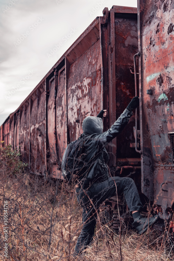 Homeless immigrant climbing on freight train