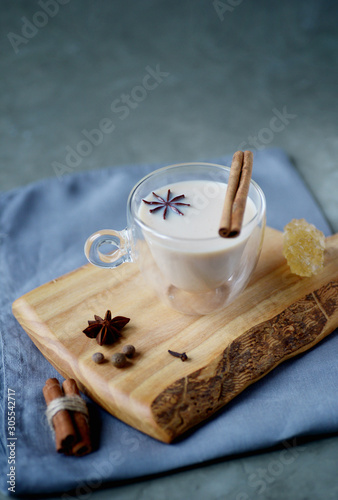 Indian masala chai tea, spiced tea with milk on rustic wooden desk, selective focus, copy space photo