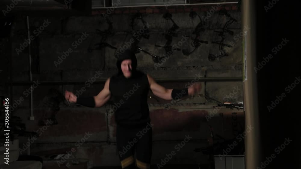 Athletic man is training with a rope in the basement. Athletic man is training with a rope in the basement.