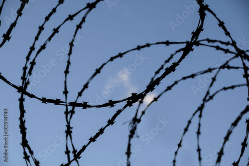 silhouette of barbed wire against the sky