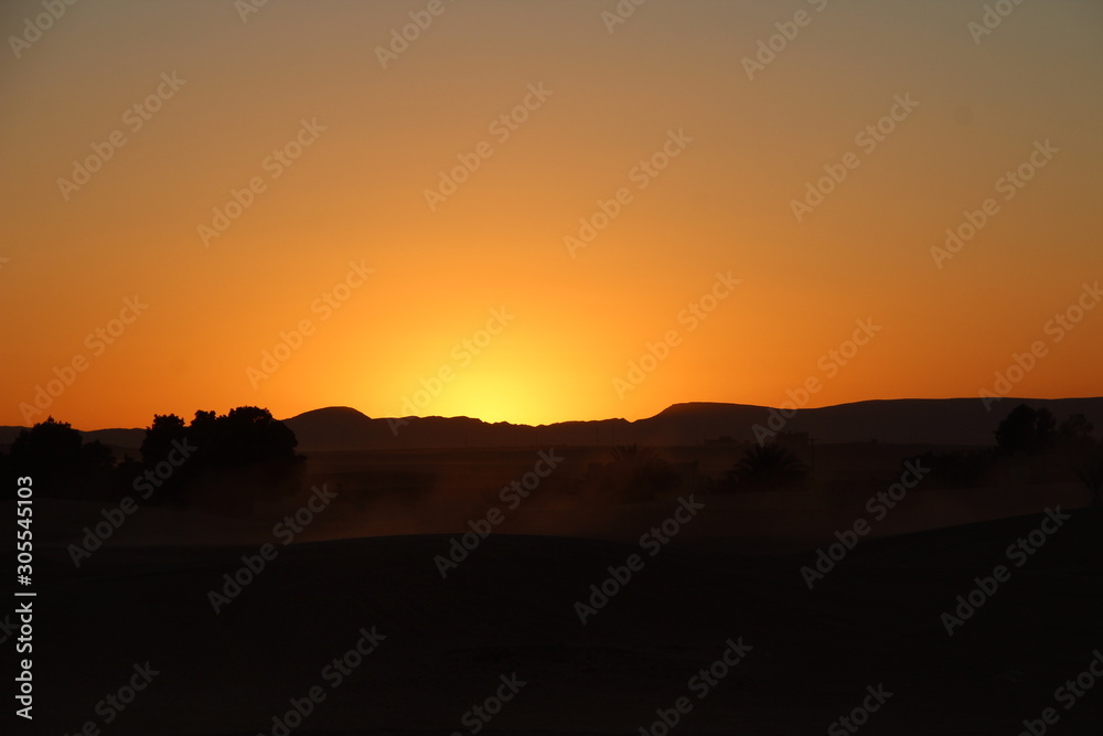 Orange sunset from the Berber camp of the Merzouga desert in the Erg Chebbi Dunes. Morocco