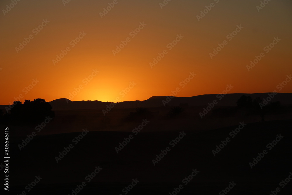 Orange sky from the Berber camp of the Merzouga desert in the Erg Chebbi Dunes. Morocco
