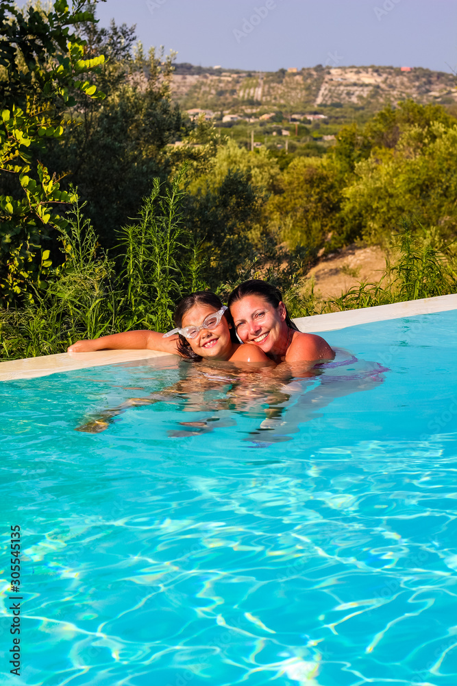 mom and daughter enjoying a swim in the pool at a resort in Sicily during the summer, Italy