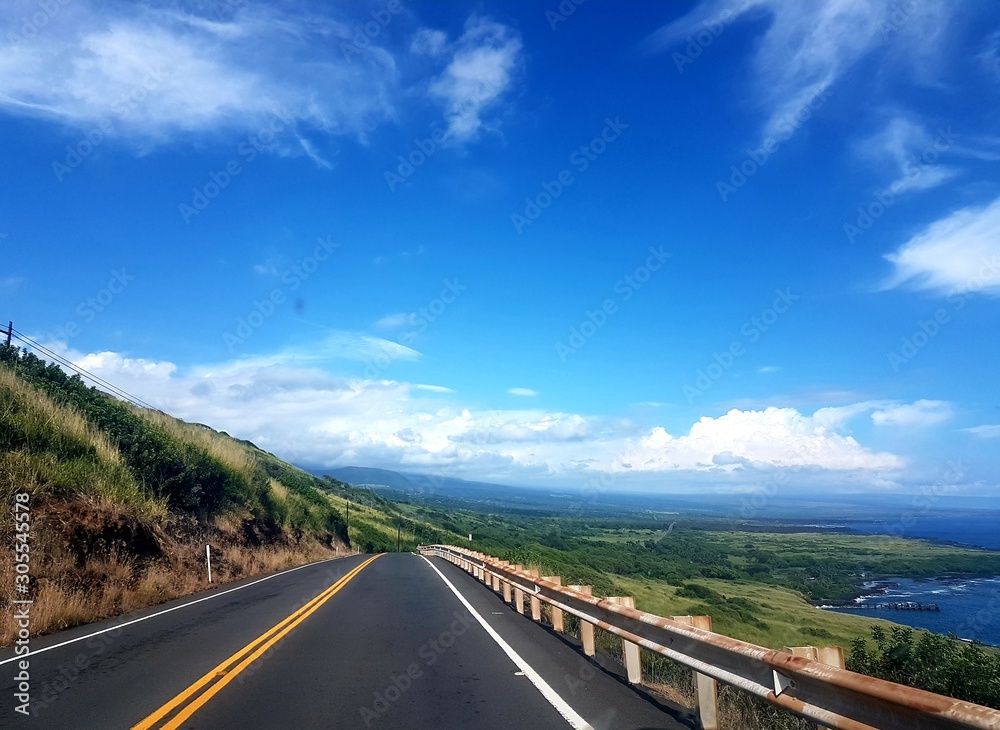 Hawaii Road with blue sky and green fields