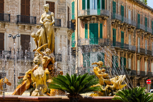 fountain full of ancient statues in the city of Syracuse in Sicily, Italy