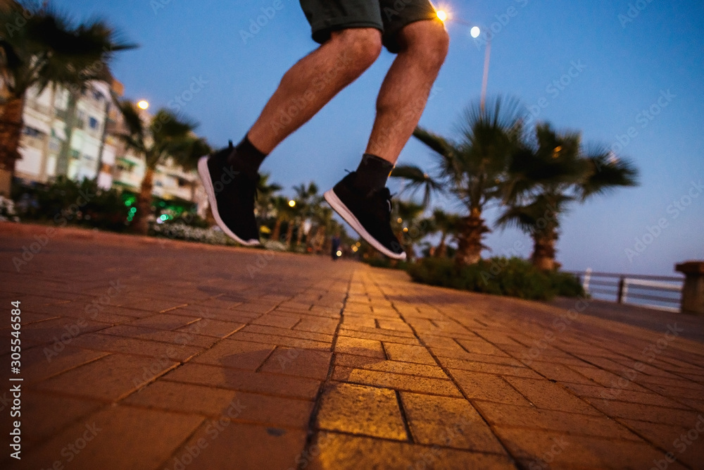 Man jumping in the dusk street of tropical city.