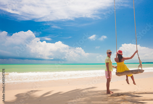 Couple in love on a swing by the sea. Couple in love on an island off the coast. Honeymoon.