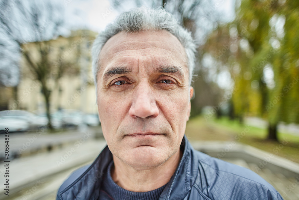 Portrait of aged serious man outdoors.