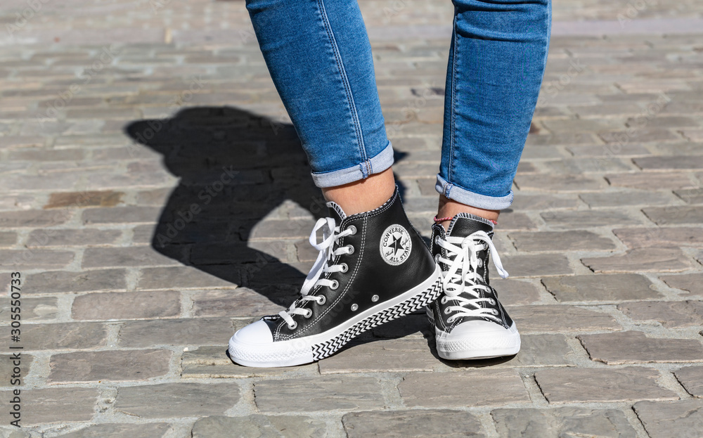 Chartres, France - Spetember 2, 2019: Image of the lower part of teenager's  legs in jeans and All Star Converse sneakers in a cobblestone street. Stock  Photo | Adobe Stock