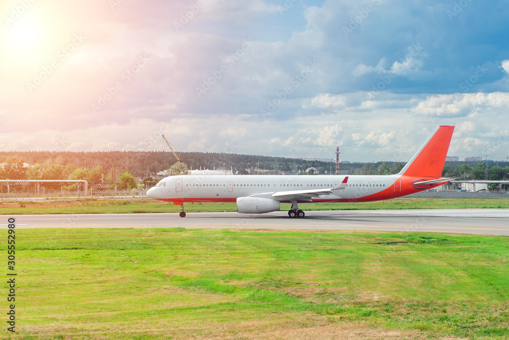 a white with a red tail passenger plane is ready to take off against the sky on a sunny day. concept of air travel a white with a red tail passenger plane is ready to take off against the sky on a sunny day. concept of air travel