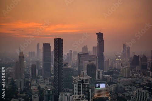 The enlightened skyscrapers of Bangkok skyline during red sunset in Thailand