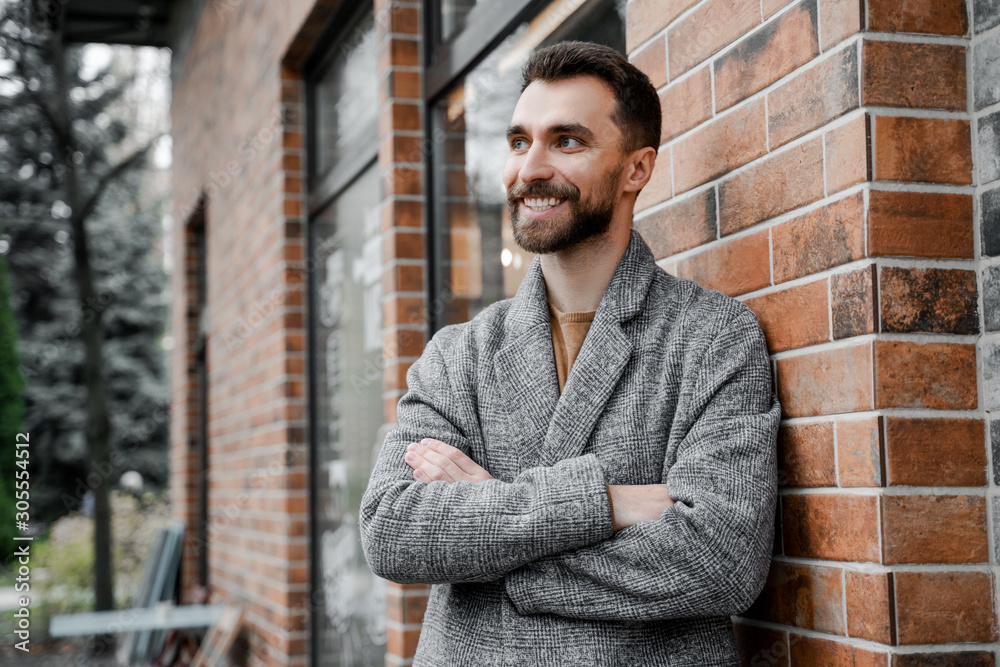 Obraz premium Portrait of a handsome young businessman standing with arms crossed. Smart caucasian young male entrepreneur having great ideas for future projects, confident lifestyle.