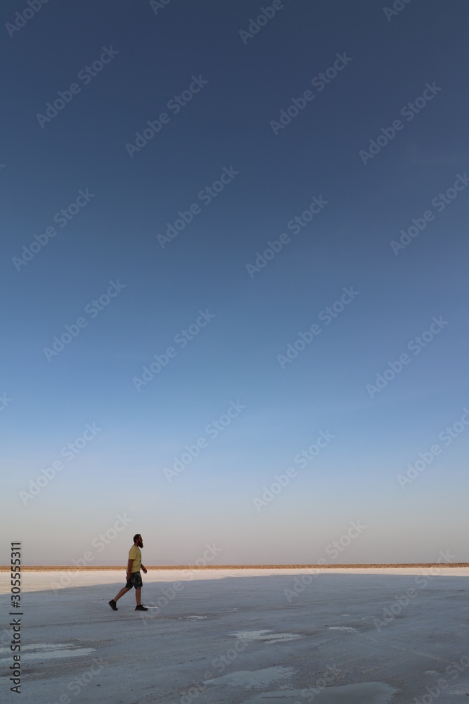Man running through the desert/on a beach at sunset
