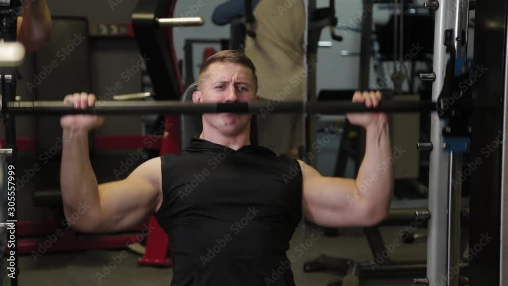 Professional athlete trains the shoulders with a barbell. Professional athlete trains the shoulders with a barbell.