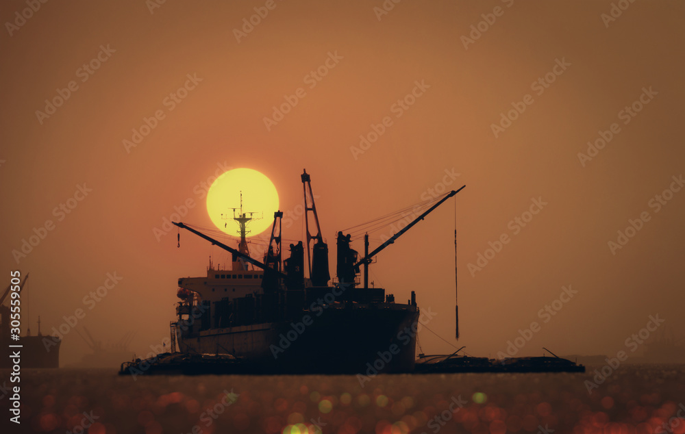 silhouette of cargo ship at sunset