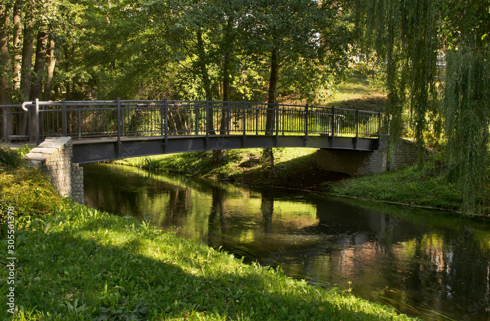 Footbridge over Lyna river and alley Chateauroux at Park Podzamcze in Olsztyn. Poland  