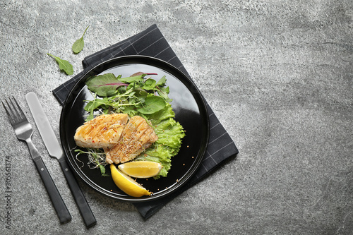 Tasty grilled fish on grey table, flat lay. Space for text