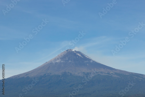 Active volcano Popocatepetl, fumarole over blue sky