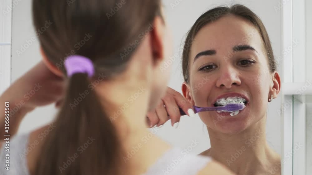 Oral hygiene for braces. Teen girl cleaning and brushing teeth with