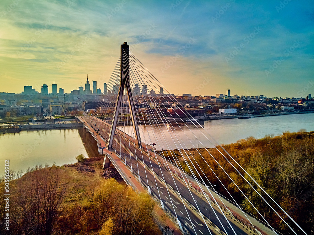 Obraz Beautiful panoramic aerial dsrone view to Swietokrzyski Bridge (English: Holy Cross Bridge) - is a cable-stayed bridge over the Vistula river in Warsaw, Poland in autumn November evening at sunset