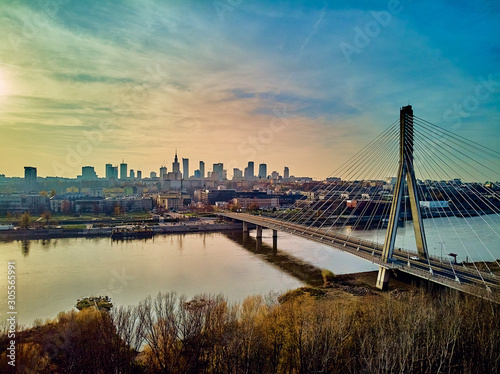 Beautiful panoramic aerial drone sunset view to Warsaw city center with skyscrapers and Swietokrzyski Bridge (En: Holy Cross Bridge) - is a cable-stayed bridge over the Vistula river in Warsaw, Poland © udmurd