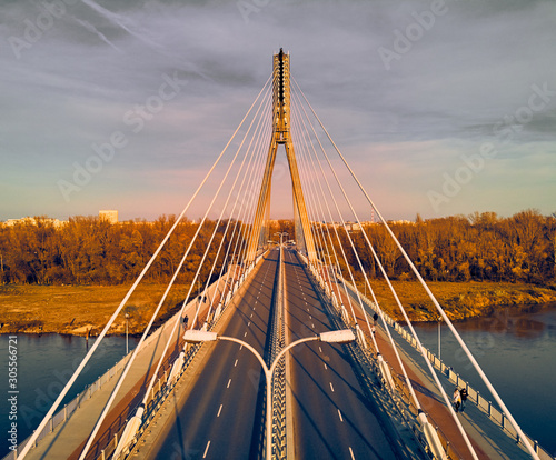 Beautiful panoramic aerial dsrone view to Swietokrzyski Bridge (English: Holy Cross Bridge) - is a cable-stayed bridge over the Vistula river in Warsaw, Poland in autumn November evening at sunset